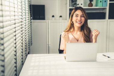 A young female employee receives a promotion, good news or finished her task and overjoyed for being a competent worker.