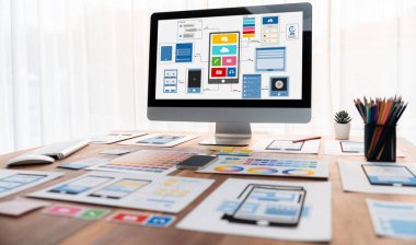Dizüstü bilgisayar ekranında web ya da mobil uygulama UI UX için dijital ve kağıt kablo tasarımları. Beyin fırtınası ve tasarım uygulama çerçevesi için geliştirici çalışma alanının panoramik görüntüsü. İnceleyin