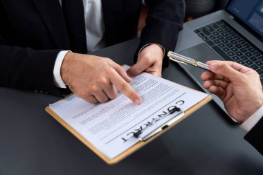 Kapanış toplantısı, iş adamı sözleşmenin şartlarını ve şartlarını dikkatle gözden geçiriyor. Şirket avukatı sözleşme anlaşmasında danışmanlık yapar. Coşkulu