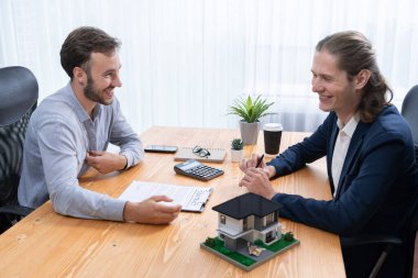 Müşteri ve emlakçı kredi sözleşmesini gözden geçirir, terimleri, faiz oranlarını ve mülkiyet haklarını tartışır. Yasal belgeleri analiz et ve karar vermeden önce anlaşmayı iyice oku. Varlık