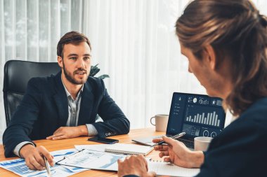 Ofisteki analist ekibi, iş performansını artırmak için bilgisayarında grafik ve çizelge olan BI gösterge panelini kullanarak çalışma alanındaki pazarlama stratejisi için finansal veri analizi yapmakla meşgul. Varlık