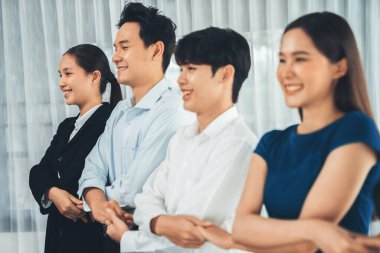 Mutlu ve gülümseyen çok ırklı ofis çalışanı, sinerjiyi ve ticari başarı için işbirliğini destekleyen bir kuyrukta el ele tutuşuyor. Modern işyerinde çeşitli profesyonel ofis çalışanları arasında bağ var. Uyum