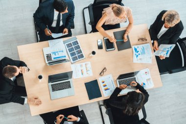 İş adamları grup toplantısı ofiste yukarıdan çekildi. İş kadınları, iş adamları ve ofis çalışanları toplantı masasında proje planlama belgeleriyle takım konferansında çalışıyorlar. Jivy