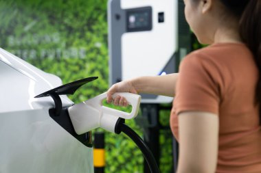 Yeşil kaynaktan karbondioksit salınımını azaltmak için şarj istasyonuna kadar sürdürülebilir enerji ve eko enerji kavramında elektrik şarj istasyonu .