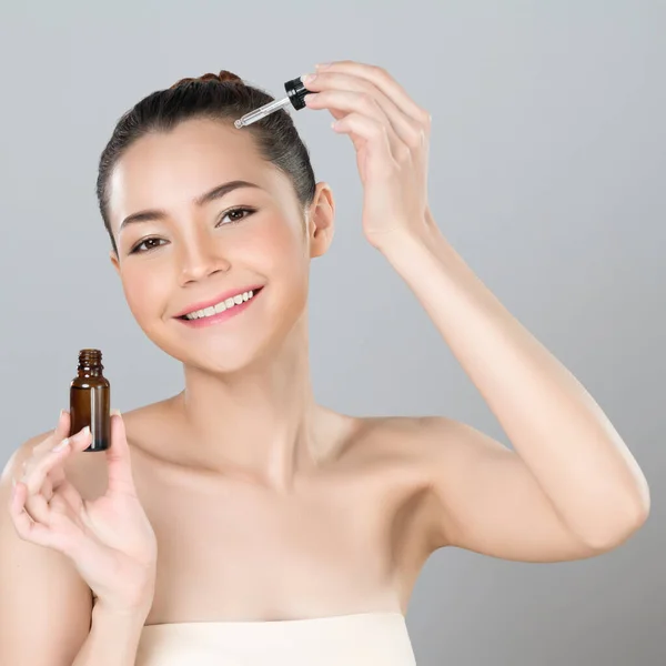 stock image Glamorous portrait of beautiful woman applying extracted cannabis oil bottle for skincare product. CBD oil dropper pipette for cosmetology treatment and cannabinoids concept in isolated background.