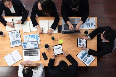 Top-view business team of financial data analysis meeting with business intelligence, report paper and dashboard on laptop for marketing strategy. Business people working together in office of harmony