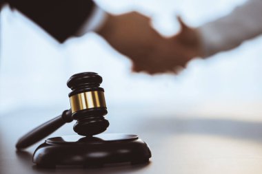 Odaklanma tokmağı avukat meslektaşlarının bulanık arkaplan üzerine adaleti sembolize eder başarılı bir hukuki anlaşmadan sonra mahkemedeki anlaşmazlığı savunmak güvenilir bir ortağın güvenilirliğini sağlar. Eşitlik
