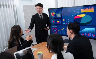 Confidence and asian businessman give presentation on financial analyzed by business intelligence in dashboard report to other people in board room meeting to promote harmony in workplace.