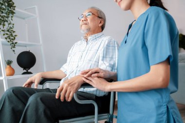 Caring nurse and a contented senior man in a wheel chair at home, nursing house. Medical for elderly patient, home care for pensioners.