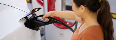 Yeşil kaynaktan karbondioksit salınımını azaltmak için şarj istasyonuna kadar sürdürülebilir enerji ve eko enerji kavramında elektrik şarj istasyonu .