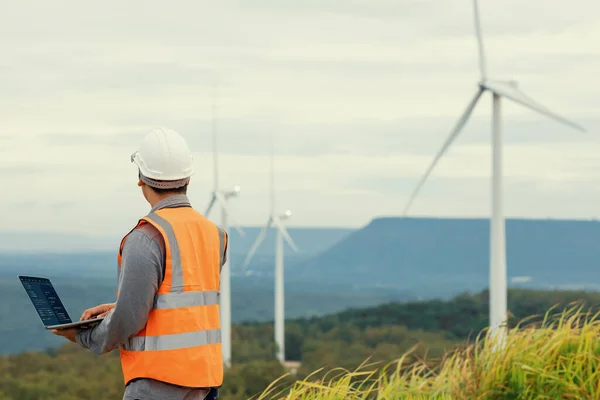 stock image Engineer working on a wind farm atop a hill or mountain in the rural. Progressive ideal for the future production of renewable, sustainable energy. Energy generation from wind turbine.