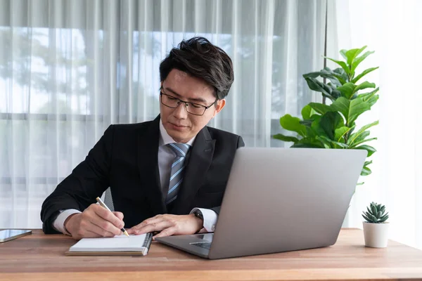 stock image Businessman working on laptop for on office desk workspace. Smart executive researching financial business data or planning strategic business marketing with computer on table. Jubilant