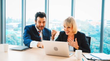 İki mutlu iş adamı ofis toplantı odasında kutlama yapıyor. Başarılı iş adamı, proje başarısını modern işyerindeki meslektaşlarıyla mali raporlar hakkında konuşurken kutluyor. Jivy