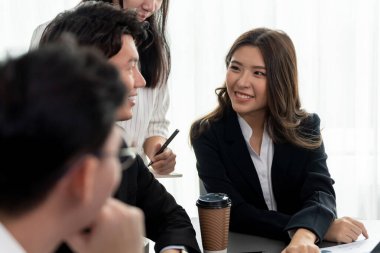 Harmony in office concept as business people analyzing dashboard paper together in workplace. Young colleagues give ideas at manager desk for discussion or strategy planning about project.