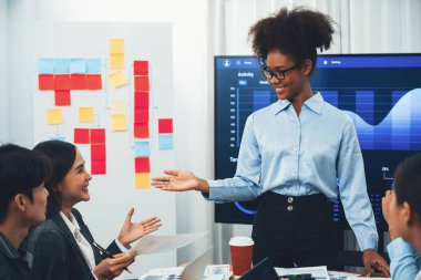 Genç Afrikalı iş kadını modern toplantıda TV ekranında veri analizi paneli sunuyor. Bir grup iş adamıyla konferans odasında iş sunumu. Uyum