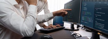 Yazılım geliştirme ekibi ofiste birlikte çalışıyor, bilgisayar ekranında betik görüntülemesi kodluyor. Teknoloji geliştirici şirketinde çalışan programcı ve yazılım mühendisi. Önde.