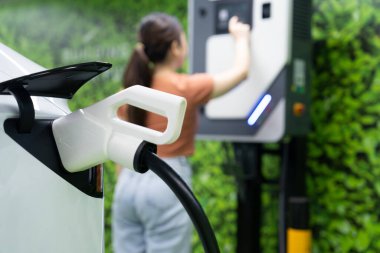 Yeşil kaynaktan karbondioksit salınımını azaltmak için şarj istasyonuna kadar sürdürülebilir enerji ve eko enerji kavramında elektrik şarj istasyonu .