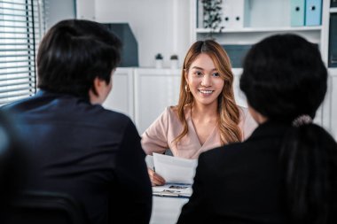 A young female asian candidate tries to impress her interviewer by being competent. International company, multicultural environment in workplace.