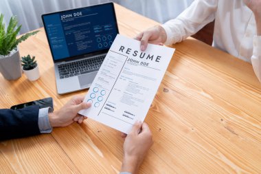 Aday özgeçmişini ya da CV 'yi şirket toplantı odasında mülakata veriyor. İş başvurusunda bulunan kişi, bilgisayar ekranında dijital özgeçmişiyle HR yöneticisine vasıflarını ve iş deneyimlerini göstermiş. Varlık