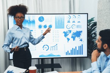 Genç Afrikalı iş kadını modern toplantıda TV ekranında veri analizi paneli sunuyor. Bir grup iş adamıyla konferans odasında iş sunumu. Uyum