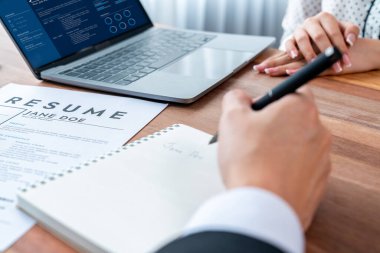 Görüşmeci ve aday arasındaki iş görüşmesi. Asyalı kadın iş başvurusu yapan kişi performansını ve niteliğini dizüstü bilgisayar ve özgeçmişiyle İnsan Kaynakları müdürüne sunar. Sevinçli.