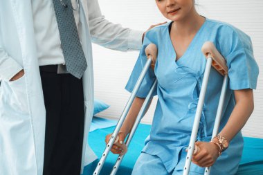 Doktor hastanede koltuk değnekli hastayla ilgileniyor. Fizyoterapist ve bacak yaralanması konsepti. Jivy