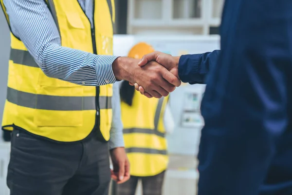stock image After concluding the meeting, competent investor shakes hands with engineer. Concept of the agreement between engineers and investors.
