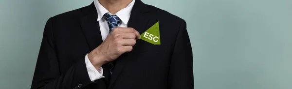 Corporate promoting sustainable and green business concept with businessman holding ESG symbol paper as environmental social government commitment using clean energy with zero CO2 emission. Alter