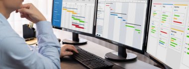 Proje yöneticisi, ekranda gantt grafik yazılım gösterimi kullanılarak ofis için iş programları planlıyor. Modern iş yönetimi ve iş akışı organizasyonu. Önde.