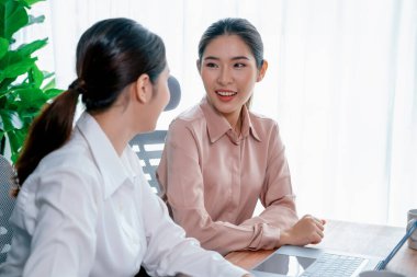 Modern ofis çalışma alanında iş birliği yapan iki genç ofis çalışanı, modern ofis çalışanı olarak profesyonelliklerini sergileyerek, dizüstü bilgisayarda tartışıyorlar ve birlikte çalışıyorlar. Coşkulu.