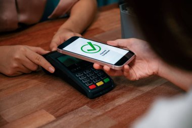 QR kodu parasız ödeme taraması için ekranda gösterilir. Kapalı eller, mobil uygulamadan elektronik işlem yoluyla para aktarmak için akıllı telefonu tutuyor. Hızlı ödeme için barkod teknolojisi. Coşkulu.