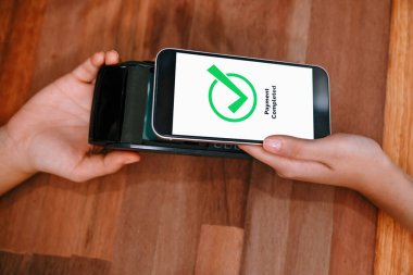 QR kodu parasız ödeme taraması için ekranda gösterilir. Kapalı eller, mobil uygulamadan elektronik işlem yoluyla para aktarmak için akıllı telefonu tutuyor. Hızlı ödeme için barkod teknolojisi. Coşkulu.