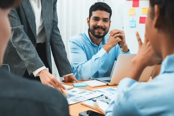 stock image Multiracial analyst team use BI dashboard data to analyze financial report on meeting table. Group of diverse business people utilize data analysis by FIntech for business marketing decision. Concord