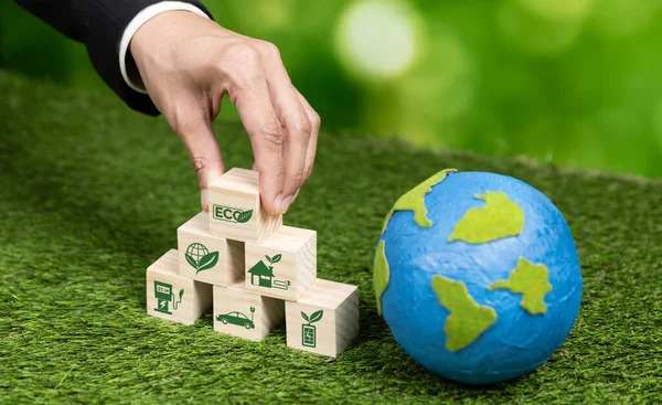 商人手拿着带有生态符号和纸地球仪的木制立方体 背景肥沃 环境意识和可持续能源 清洁和可再生能源促进更绿色的生态 改变了 — 图库照片