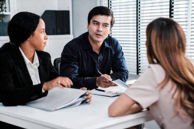 A young female asian candidate tries to impress her interviewer by being competent. International company, multicultural environment in workplace.