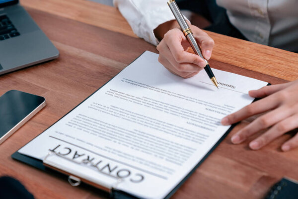 Closeup hand signing contract document with pen, sealing business deal with signature. Businesspeople finalizing business agreement by writing down signature on contract paper. Enthusiastic