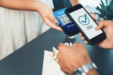 Parasız ödeme taraması için QR kodu ekranda görüntülendi. Kapalı eller, mobil uygulamadan elektronik işlem yoluyla para aktarmak için akıllı telefonu tutuyor. Hızlı ödeme için barkod teknolojisi. Coşkulu