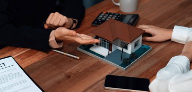 Temsilciyle ev kredisi sözleşmesini gözden geçiriyorum. Mali belgeleri ve vergi oranlarını, mülkiyet sahibi olmak için hesap makinesiyle analiz ediyorum. Yeni ev alımı ve finansman için anahtar imza. Coşkulu.