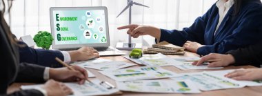 ESG 'nin çevresel sosyal yönetimi, çevre dostu şirket toplantılarında, temiz ve sürdürülebilir gelecekteki ekoloji için çevre korumasını uygulayan iş adamlarıyla dizüstü bilgisayarda sergileniyor. Önde.