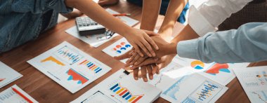 Analist ekibi, iş stratejisi ve pazarlama için finansal konsol belgelerini başarıyla analiz ettikten sonra el ele verdi. Takım çalışması ve birlik el ele tutuşarak ofiste. Panorama çekimi. İnceleyin