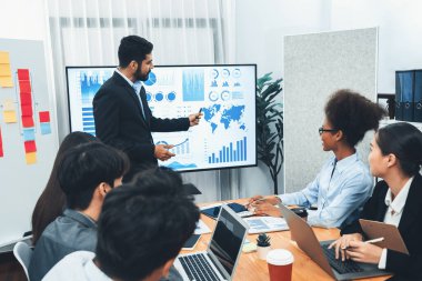 Pazarlama stratejisi için modern toplantıda veri analizi paneli ekranında sunan bir işadamı. Bir grup iş adamıyla konferans odasında iş sunumu. Uyum
