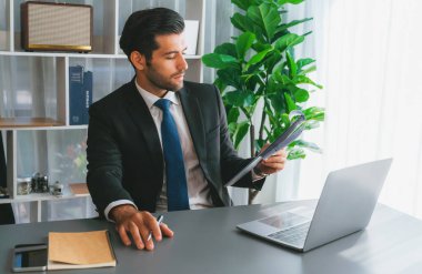Modern ofis masasındaki modern profesyonel iş adamı çalışmak ve notlar yazmak için dizüstü bilgisayar kullanıyor. Ofisinde bilgisayar defteri üzerinde çalışan çalışkan bir ofis çalışanı. coşkulu