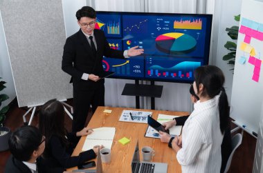 Confidence and asian businessman give presentation on financial analyzed by business intelligence in dashboard report to other people in board room meeting to promote harmony in workplace.