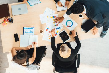 İş adamları grup toplantısı ofiste yukarıdan çekildi. İş kadınları, iş adamları ve ofis çalışanları toplantı masasında proje planlama belgeleriyle takım konferansında çalışıyorlar. Jivy