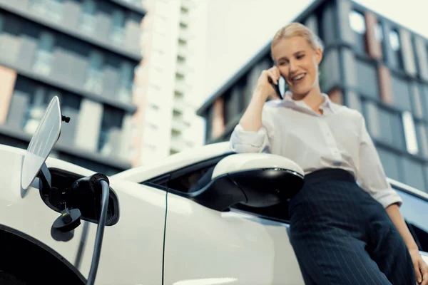 Focus Charging Electric Car Charger Charging Station Blur Businesswoman Talking — Fotografia de Stock