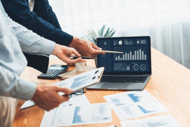 Ofisteki analist ekibi, iş performansını artırmak için bilgisayarında grafik ve çizelge olan BI gösterge panelini kullanarak çalışma alanındaki pazarlama stratejisi için finansal veri analizi yapmakla meşgul. Varlık