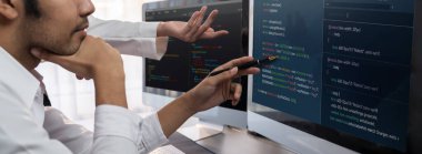 Yazılım geliştirme ekibi ofiste birlikte çalışıyor, bilgisayar ekranında betik görüntülemesi kodluyor. Teknoloji geliştirici şirketinde çalışan programcı ve yazılım mühendisi. Önde.