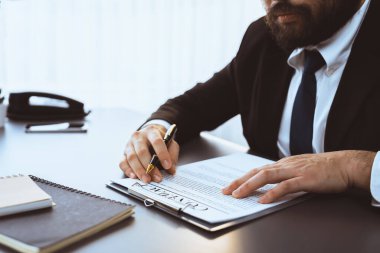 İş adamı sözleşme kağıtlarını ya da iş hukukunu güven ve profesyonellikle imzalar. Resmi iş anlaşması için şirket toplantısında el ele tutuşmak. Eşitlik