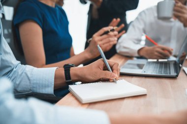Sekreter, toplantı odasında görüşen bir grup çok ırklı iş adamıyla şirket toplantısında defterine not alıyor. Modern ofiste profesyonel toplantılarda çeşitlilik. Uyum