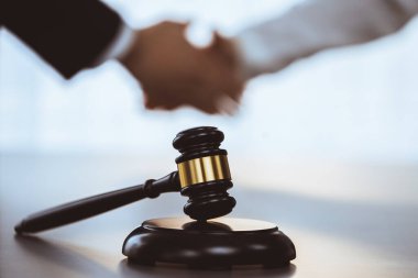 Odaklanma tokmağı avukat meslektaşlarının bulanık arkaplan üzerine adaleti sembolize eder başarılı bir hukuki anlaşmadan sonra mahkemedeki anlaşmazlığı savunmak güvenilir bir ortağın güvenilirliğini sağlar. Eşitlik